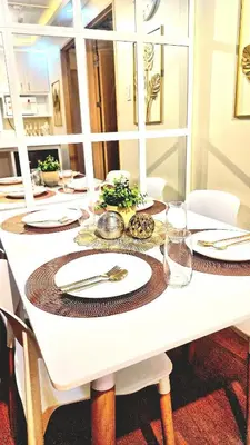 a white table with plates and silverware on it at Veronica Grey's Staycation 2BR in Manila