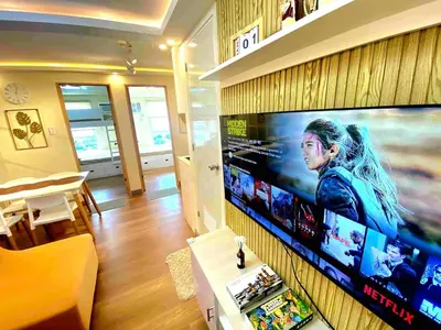 a living room with a large flat screen tv on a wall at Veronica Grey's Staycation 1BR in Manila