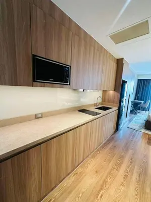 a kitchen with wooden cabinets and a counter top at Novotel Executive Hotel at Rosalina Acqua Residence in Manila
