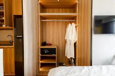 a bedroom with a closet with a robe and a bed at Novotel Executive Hotel at Rosalina Acqua Residence in Manila