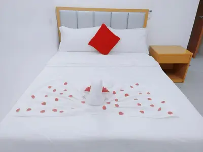 a bedroom with a white bed with a red pillow at SD HOTEL Taytay in Taytay