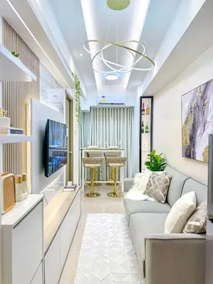 a living room with a couch and a tv at Eastovia Suites city center condo with pool at Fame in Manila