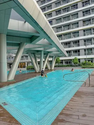 a swimming pool in front of a building at Eastovia Suites city center condo with pool at Fame in Manila
