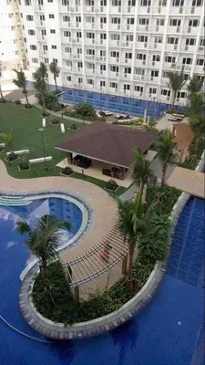 arial view of a hotel with a pool and a large building at StayWisePH at MOA in Manila