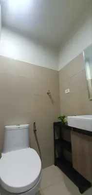 a bathroom with a white toilet and a sink at StayWisePH at MOA in Manila