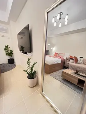 a mirror in a bedroom with a bed and a couch at The Fresh Escape in Manila