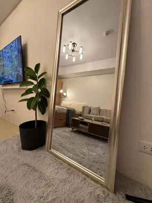 a large mirror in a living room with a couch at The Fresh Escape in Manila