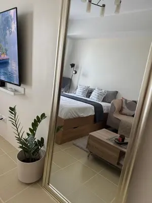 a mirror in a bedroom with a bed and a couch at The Fresh Escape in Manila