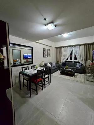 a living room with a table and chairs and a couch at Newport 150 - 1 BR staycation near NAIA 3 in Manila