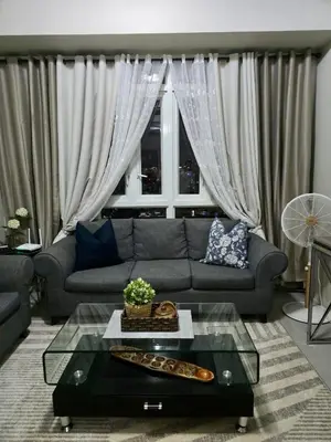 a living room with a couch and a table at Newport 150 - 1 BR staycation near NAIA 3 in Manila