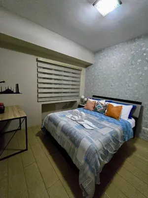 a bedroom with a bed with pillows and a window at Newport 150 - 1 BR staycation near NAIA 3 in Manila