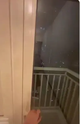a person is opening a door to a balcony at Coast Residences in Manila
