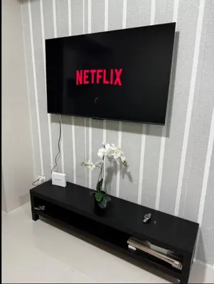a television sitting on top of a table with a plant at C12F JRM Staycation Naia T3 Near Airport With Parking in Manila