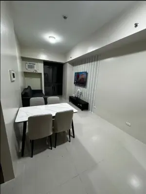 a dining room with a table and chairs and a couch at C12F JRM Staycation Naia T3 Near Airport With Parking in Manila