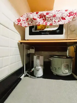 a kitchen shelf with a microwave and a toaster at Agate's Loft in Manila