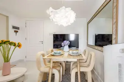a dining room with a table and chairs and a mirror at Jing'sCrib 2BR Apartment by Azure Near Manila International Airport in Manila