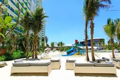 a resort with palm trees and a playground at Jing'sCrib 2BR Apartment by Azure Near Manila International Airport in Manila