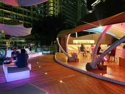 a group of people sitting on a deck at night at Jing'sCrib 2BR Apartment by Azure Near Manila International Airport in Manila