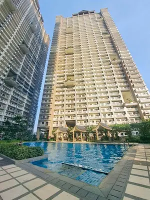 two tall buildings with a swimming pool in front of them at Apartment in KAI Garden Residences in Manila