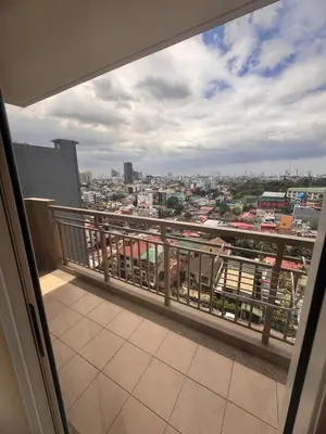 a balcony with a view of a city at Apartment in KAI Garden Residences in Manila