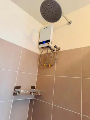 a shower in a bathroom with a wall mounted camera at Apartment in KAI Garden Residences in Manila