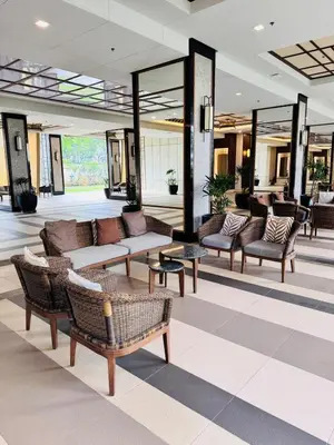 a lobby with couches and chairs in a building at Apartment in KAI Garden Residences in Manila
