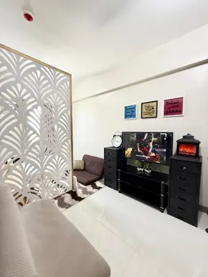 a living room with a tv and a wall at Maiko Happy Studio near US Embassy in Manila