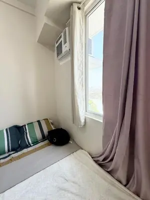 a small bedroom with a bed and a window at Maiko Happy Studio near US Embassy in Manila