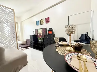a living room with a table and a couch at Maiko Happy Studio near US Embassy in Manila