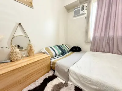 a bedroom with two beds and a mirror at Maiko Happy Studio near US Embassy in Manila