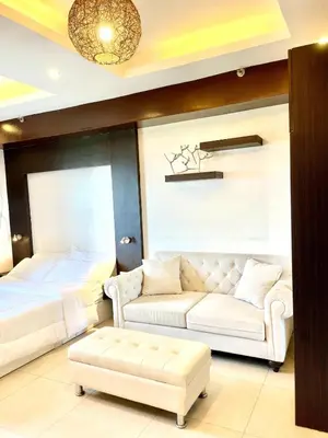 a living room with a couch and a bed at Cozy studio suite near Eastwood QC in Manila