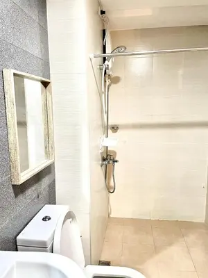 a bathroom with a shower and a toilet at Cozy studio suite near Eastwood QC in Manila