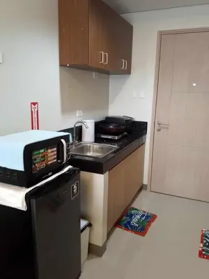 a small kitchen with a sink and a microwave at Charm Residences Staycation by Ashti in Manila