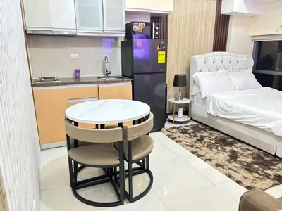 a small kitchen with a table and a bed at Cozy Studio near BGC Super Fast Wi-Fi in Manila