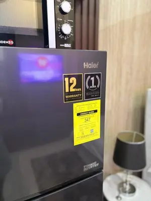 a microwave with two stickers on the side of it at Cozy Studio near BGC Super Fast Wi-Fi in Manila