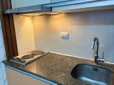 a kitchen counter with a sink and a stove at Cozy Studio near BGC Super Fast Wi-Fi in Manila