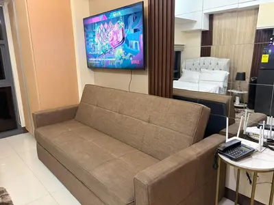 a living room with a couch and a bed at Cozy Studio near BGC Super Fast Wi-Fi in Manila