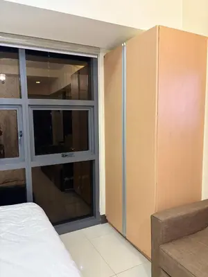 a bedroom with a large window and a bed at Cozy Studio near BGC Super Fast Wi-Fi in Manila