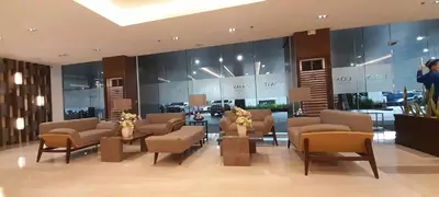 a lobby with chairs and tables in a building at Coast Residences in Manila