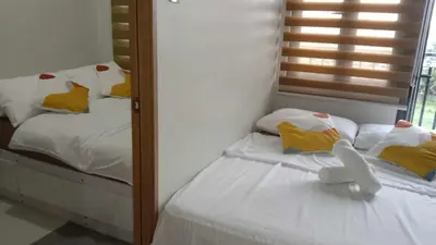 two twin beds in a room with a mirror at Shore 3 Tower 2 near MOA Parking WI-FI Netflix in Manila