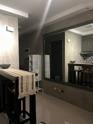 a kitchen with a table and a large mirror at Compact Urban Studio-Type Unit in Manila