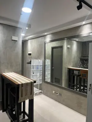 a bathroom with a large mirror and a table at Compact Urban Studio-Type Unit in Manila