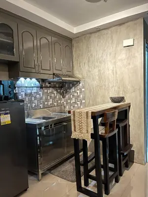 a kitchen with stainless steel appliances and a counter at Compact Urban Studio-Type Unit in Manila