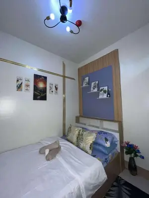 a bedroom with a bed with a stuffed animal on it at Shore 3 Residences Staycation in Manila