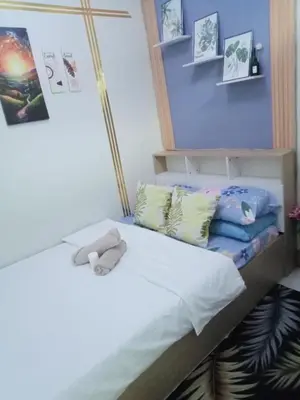 a bed with a stuffed animal sitting on top of it at Shore 3 Residences Staycation in Manila