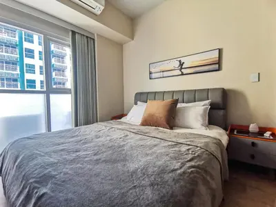 a bedroom with a bed and a window at Modern Condo in Prime Location in Manila