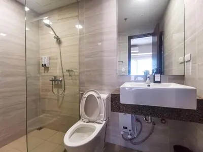 a bathroom with a toilet and a sink and a shower at Modern Condo in Prime Location in Manila