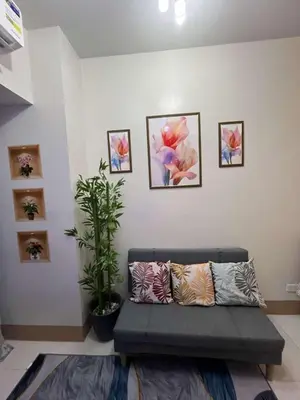 a living room with a couch and pictures on the wall at Shore 3 Residences Staycation in Manila