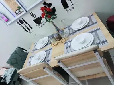 a table and chairs with plates and a vase with flowers at Shore 3 Residences Staycation in Manila