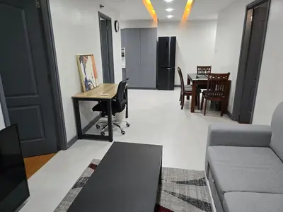 a living room with a couch and a desk at BGC Center Decent 74sqm, 2br, 2baths, 4beds with maid quarter in Manila